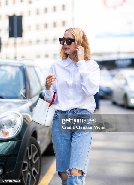 Candela Novembre wearing ripped denim jeans, white button shirt, white bucket bag is seen outside Marni during Milan Men's Fashion Week Spring/Summer...