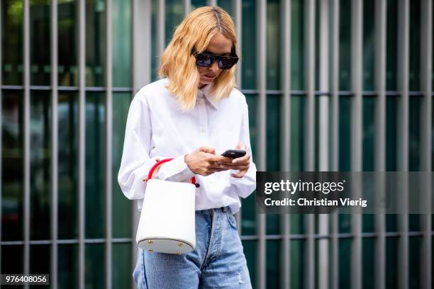 Candela Novembre wearing ripped denim jeans, white button shirt, white bucket bag is seen outside Marni during Milan Men's Fashion Week Spring/Summer...