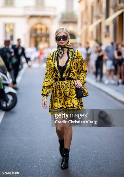 Xenia Adonts wearing scarf around her head, Versace skirt and button shirt is seen outside Versace during Milan Men's Fashion Week Spring/Summer 2019...