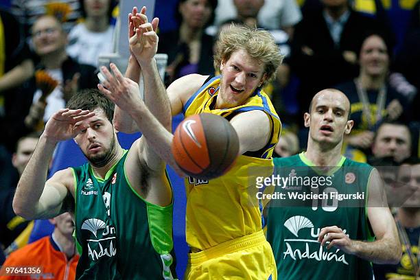 Jan-Hendrick Jagla, #14 of Asseco Prokom competes with Joel Freeland, #19 and Carlos Jimenez, #10 of Unicaja Malaga in action during the Euroleague...