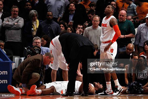 Arinze Onuaku of the Syracuse Orange lays on the floor after being injured as teammate Scoop Jardine looks on against the Georgetown Hoyas during the...