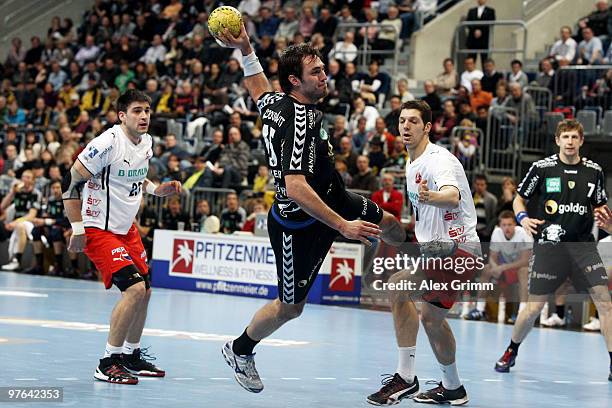 Michael Mueller of Rhein-Neckar Loewen is challenged by Nenad Vuckovic and Felix Danner of Melsungen during the Toyota Handball Bundesliga match...