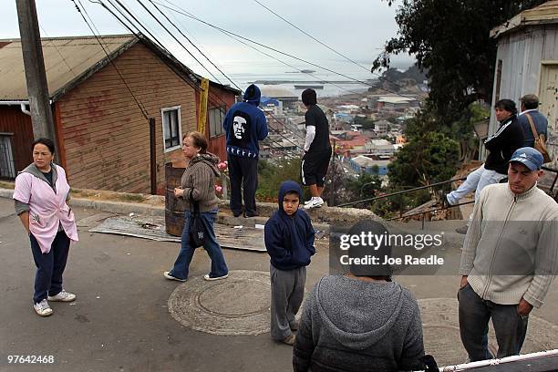 People stand together after evacuating a low lying area when an aftershock created a tsunami warning on March 11, 2010 in Talcahuano, Chile. With the...