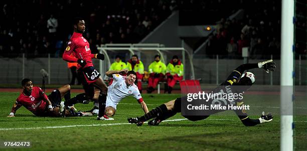 Steven Gerrard of Liverpool is denied by Aurelien Chedjou and Mickael Landreau of Lille during the UEFA Europa League last 16, 1st leg match between...