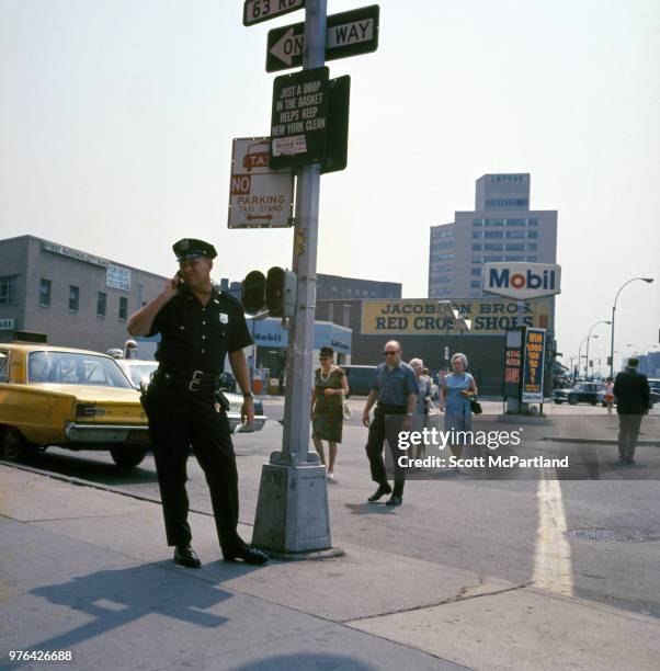 New York City - A police officer talk on the phone at a call box on an unspecified street corner in Queens, New York.