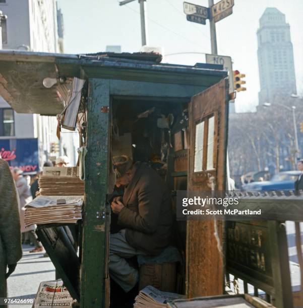 New York City - View of a newspaper vendor as he sits in an wooden news stand at the corner of 42nd Street and 6th Avenue in midtown Manhattan.
