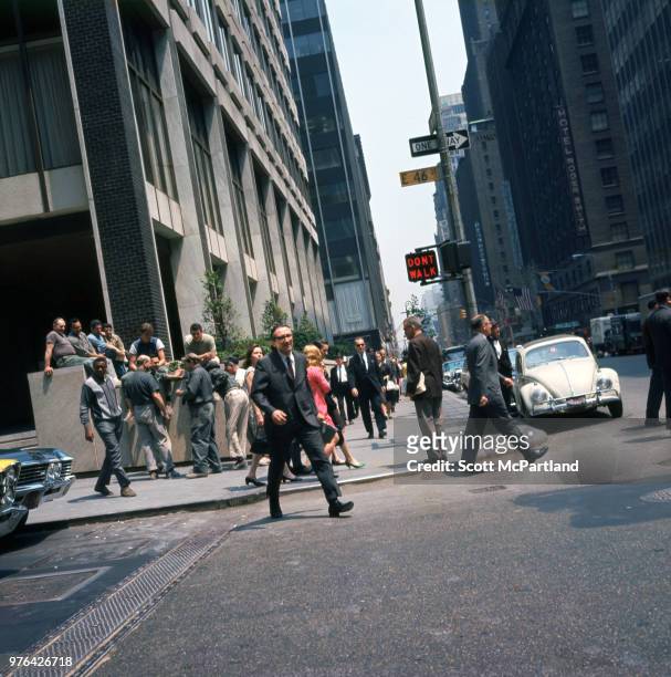 New York City - Crowds gather on the sidewalks and steps of buildings at the intersection of East 46th Street and Lexington Avenue in midtown...