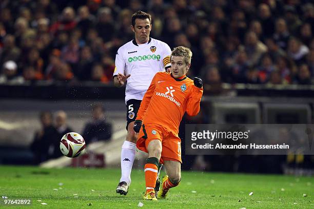 Marko Marin of Bremen battles for the ball with Carlos Marchena of Valencia during the UEFA Europa League round of 16 first leg match between...