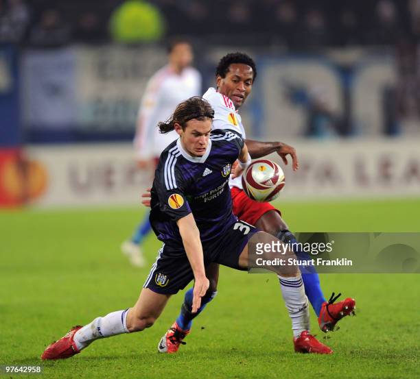 Ze Roberto of Hamburg is challenged by Guillaume Gillet of Anderlecht during the UEFA Europa League round of 16 first leg match between Hamburger SV...