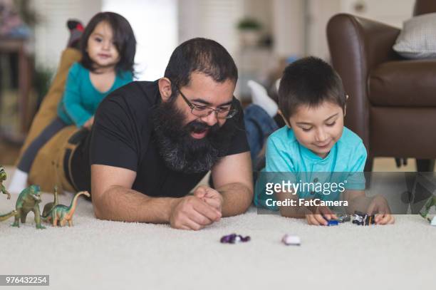 vader en zoon spelen met speelgoed auto's op de vloer - legacy stockfoto's en -beelden