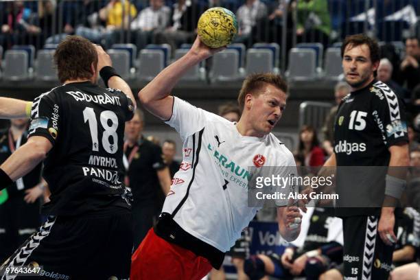 Thomas Klitgaard of Melsungen is challenged by Bjarte Myrhol and Michael Mueller of Rhein-Neckar Loewen during the Toyota Handball Bundesliga match...