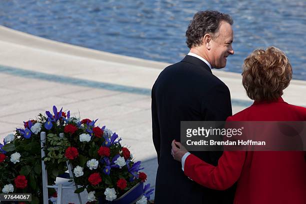 Former Sen. Elizabeth Dole places her hand on the back of actor Tom Hanks after a wreath-laying ceremony during a World War II Memorial ceremony to...