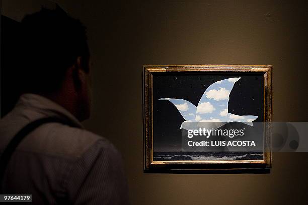 Visitor looks at the painting "The Promise " by Belgian artist Rene Magritte, exhibited during a press conference at the Fine Arts Palace in Mexico...