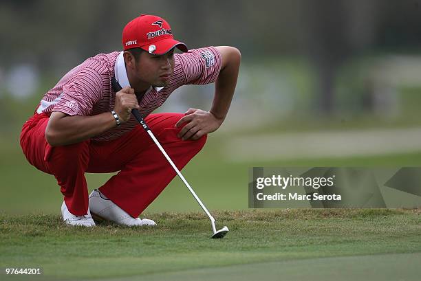 Yuta Ikeda of Japan lines up a putt on the 11th hole during round one of the 2010 WGC-CA Championship at the TPC Blue Monster at Doral on March 11,...