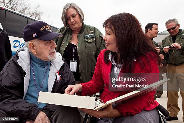 On right, Tammy Duckworth, Assistant Secretary of the Department of Vetrans Affairs, looks at a vetran's scrapbook during a World War II Memorial...
