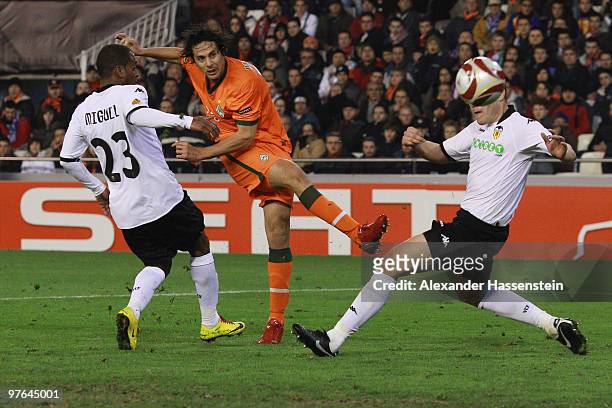 Claudio Pizzarro of Bremen battles for the ball with Miguel of Valencia and his team mate David Navarro during the UEFA Europa League round of 16...