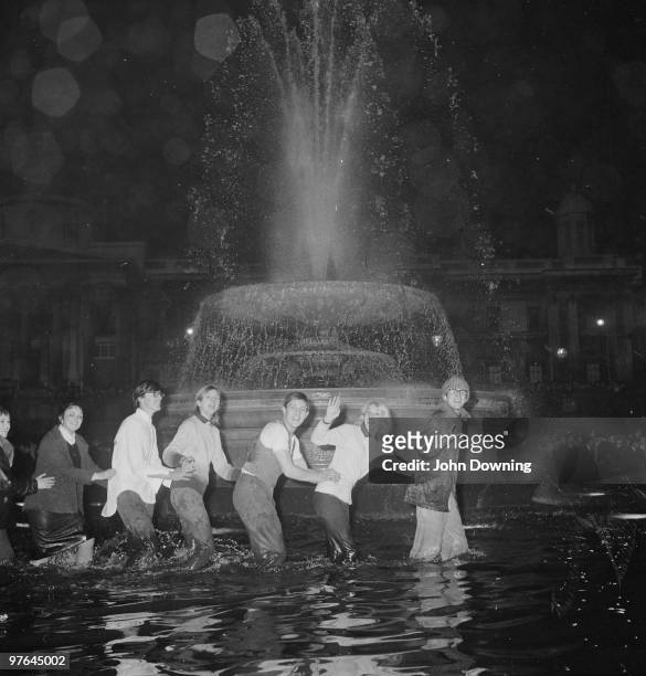 Revellers in a fountain at Trafalgar Square during New Years Eve celebrations.
