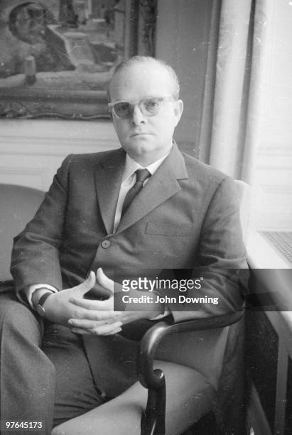 American novelist Truman Capote sits with his hands clasped.