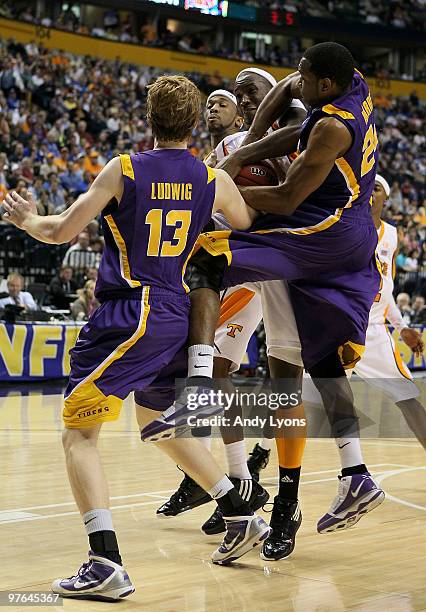 Wayne Chism of the Tennessee Volunteers fights for control of the ball in the second half against Eddie Ludwig and Storm Warren of the LSU Tigers...