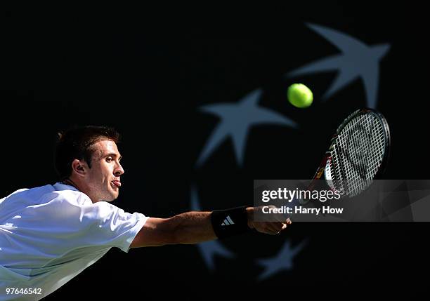 Tim Smyczek of the United States stretches for a backhand in his match against Carlos Moya of Spain during the BNP Paribas Open at the Indian Wells...
