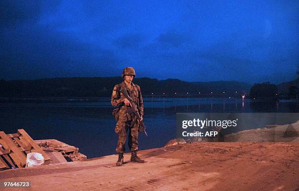 Chilean soldier stands guard controling that the imposed curfew be respected in Constitucion, some 350 kms south of Santiago on March 11, 2010. A...