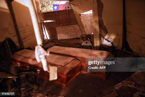 Coffins are seen amid the rubble of a destroyed building in Constitucion, some 350 kms south of Santiago on March 11, 2010. A 6.9-magnitude...