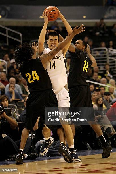 Max Zhang of the California Golden Bears is trapped by LeKendric Longmire and Matthew Humphrey of the Oregon Ducks during the quarterfinals of the...