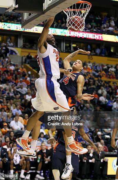 Alex Tyus of the Florida Gators dunks against Lucas Hargrove of the Auburn Tigers during the first round of the SEC Men's Basketball Tournament at...