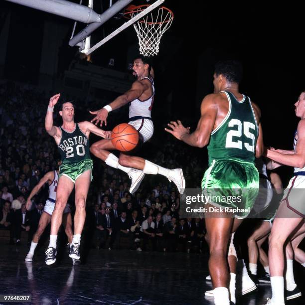 Bailey Howell passes to teammate K.C. Jones of the Boston Celtics against Wilt Chamberlain of the Philadelphia 76ers during a game played in 1967 at...