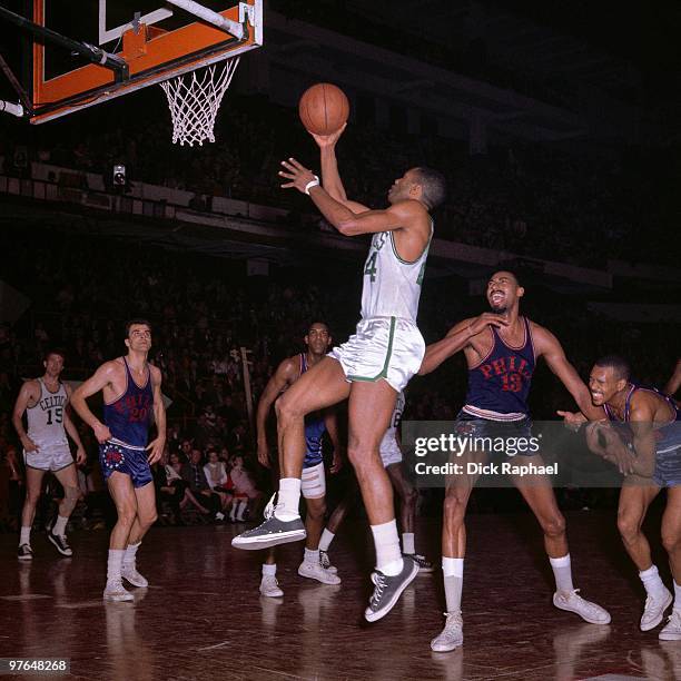 Sam Jones of the Boston Celtics shoots a layup against Wilt Chamberlain of the Philadelphia 76ers during a game played in 1965 at the Boston Garden...