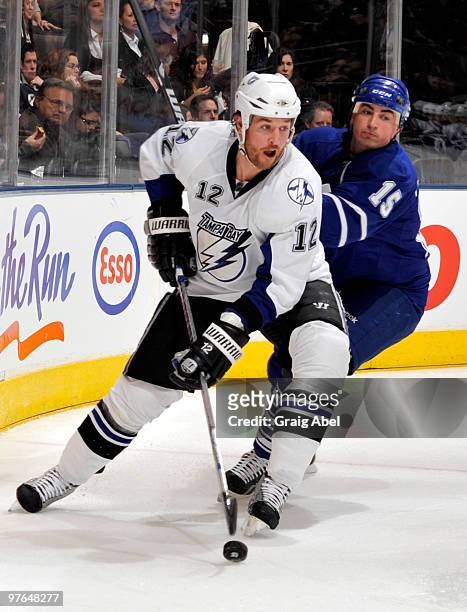 Ryan Malone of the Tampa Bay Lightning skates the puck away from Tomas Kaberle of the Toronto Maple Leafs during game action March 11, 2010 at the...