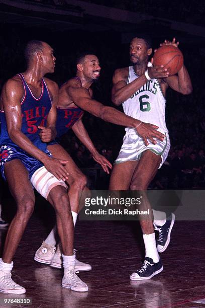Bill Rusell of the Boston Celtics makes a move to the basket against Wilt Chamberlain and Luke Jackson of the Philadelphia 76ers during a game played...