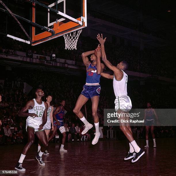 Wilt Chamberlain of the Philadelphia 76ers goes up for a shot against Bill Russell of the Boston Celtics during a game played in 1965 at the Boston...
