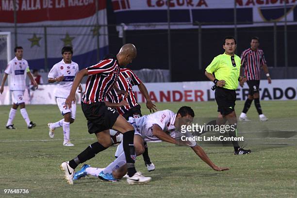 Victor Aquino of Paraguayan Nacional vies for the ball with Alex Silva and Junior Cesar of Brazilian Sao Paulo during their 2010 Santander...