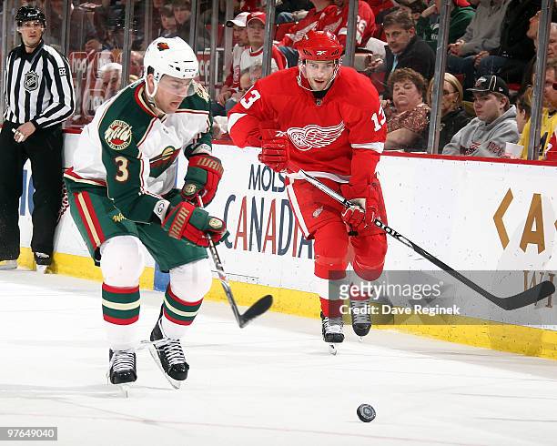 Marek Zidlicky of the Minnesota Wild and Pavel Datsyuk of the Detroit Red Wings skate up ice to the loose puck during an NHL game at Joe Louis Arena...