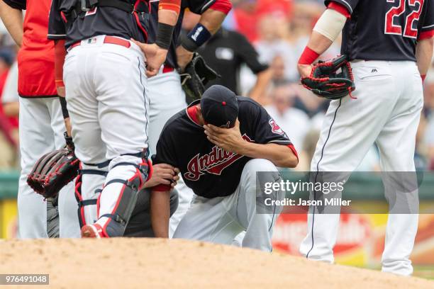 Starting pitcher Carlos Carrasco of the Cleveland Indians gets attention from a trainer after being hit by a line drive off the bat of Joe Mauer of...