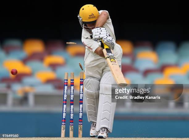 Liam Davis of the Warriors is clean bowled by Ben Cutting of the Bulls during the Sheffield Shield match between the Queensland Bulls and the Western...