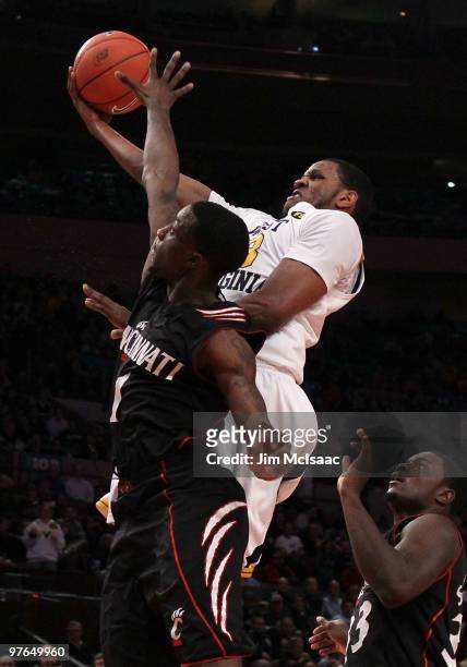 Devin Ebanks of the West Virginia Mountaineers drives to the hoop against Cashmere Wright of the Cincinnati Bearcats during the quarterfinal of the...