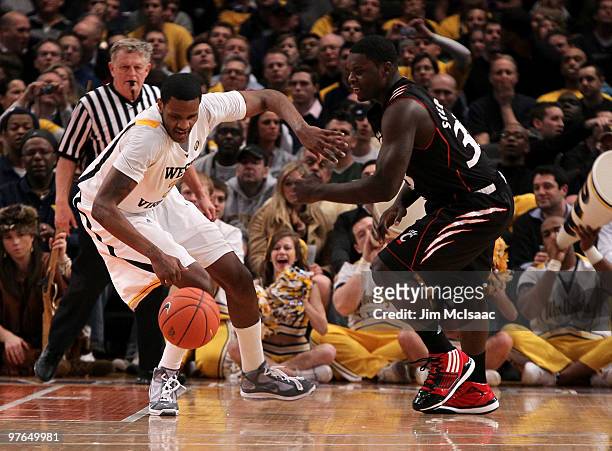 Lance Stephenson of the Cincinnati Bearcats goes for a loose ball against Devin Ebanks of the West Virginia Mountaineers during the quarterfinal of...
