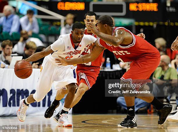 Demontez Stitt of the Clemson Tigers drives through Javier Gonzalez and Richard Howell of the NC State Wolfpack in their first round game in the 2010...