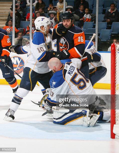 Andy MacDonald of the St. Louis Blues and Jon Sim of the New York Islanders get tangled up as goaltender Chris Mason loses his helmet on March 11,...