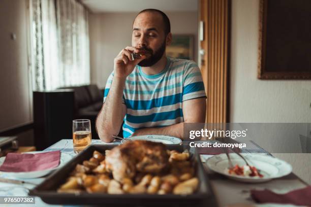 junger mann aperitif zu trinken, vor dem mittagessen - eating chicken stock-fotos und bilder