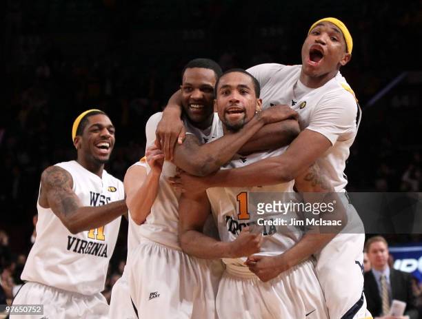 Da'Sean Butler of the West Virginia Mountaineers celebrates with teammates John Flowers, Devin Ebanks and Kevin Jones after making a game winning...
