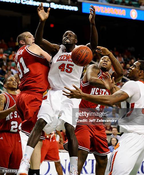 Jerai Grant of the Clemson Tigers fights for a rebound between Dennis Horner and Richard Howell of the North Carolina State Wolfpack in their...