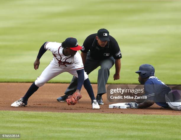 Second baseman Jose Pirela of the San Diego Padres slides into second base for a double in front of the tag by second baseman Ozzie Albies of the...