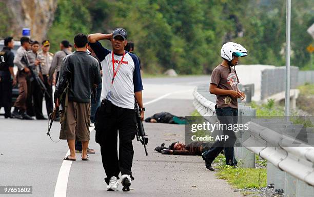 Two bodies lie on the road after police gunned down terror suspects in Leupung, Aceh Besar on March 12, 2010. Two terror suspects were killed and...