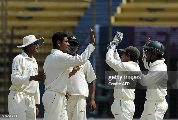 Bangladeshi cricketers celebrate after the dismissal of unseen England batsman Michael Carberry during the first day of play in the first Test match...