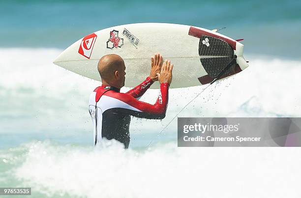 Kelly Slater of the United States inspects his board during an aerial expression session on day one of Surfsho at Bondi Beach on March 12, 2010 in...