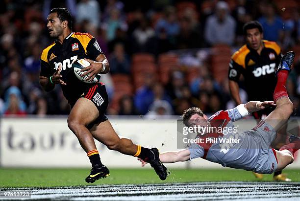 Lelia Masaga of the Chiefs breaks through the tackle of Colin Slade of the Crusaders during the round five Super 14 match between the Chiefs and the...