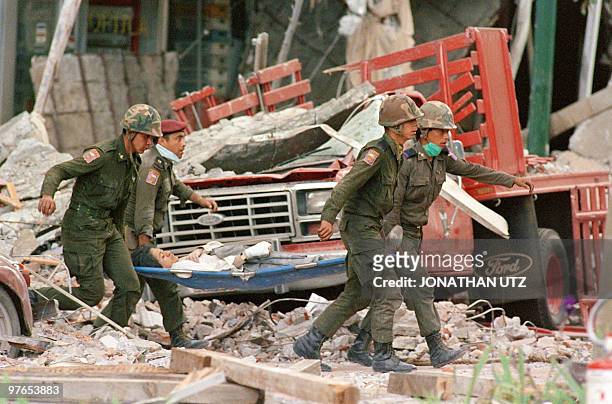 Soldiers carry a victim 21 September 1985 from a collapsed building after an earthquake leveled parts of Mexico City 19 September 1985.